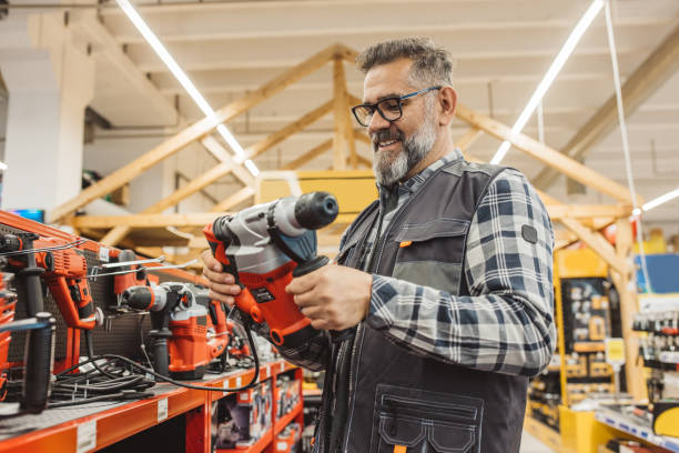 Carpenter Shopping in hardware store. He is looking for different type of working equipment.